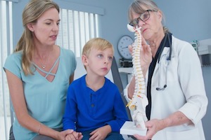 Doctor showing spine to child