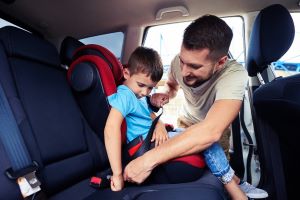 man fastening his son's seatbelt