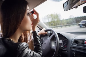 Woman using makeup while driving 